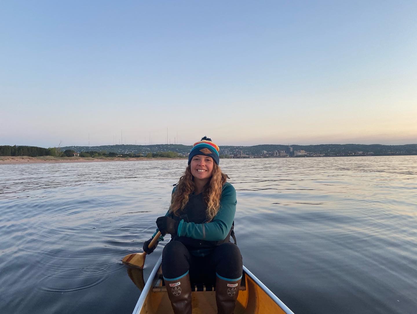 Jen in a canoe during a sunrise paddle on Lake Superior.